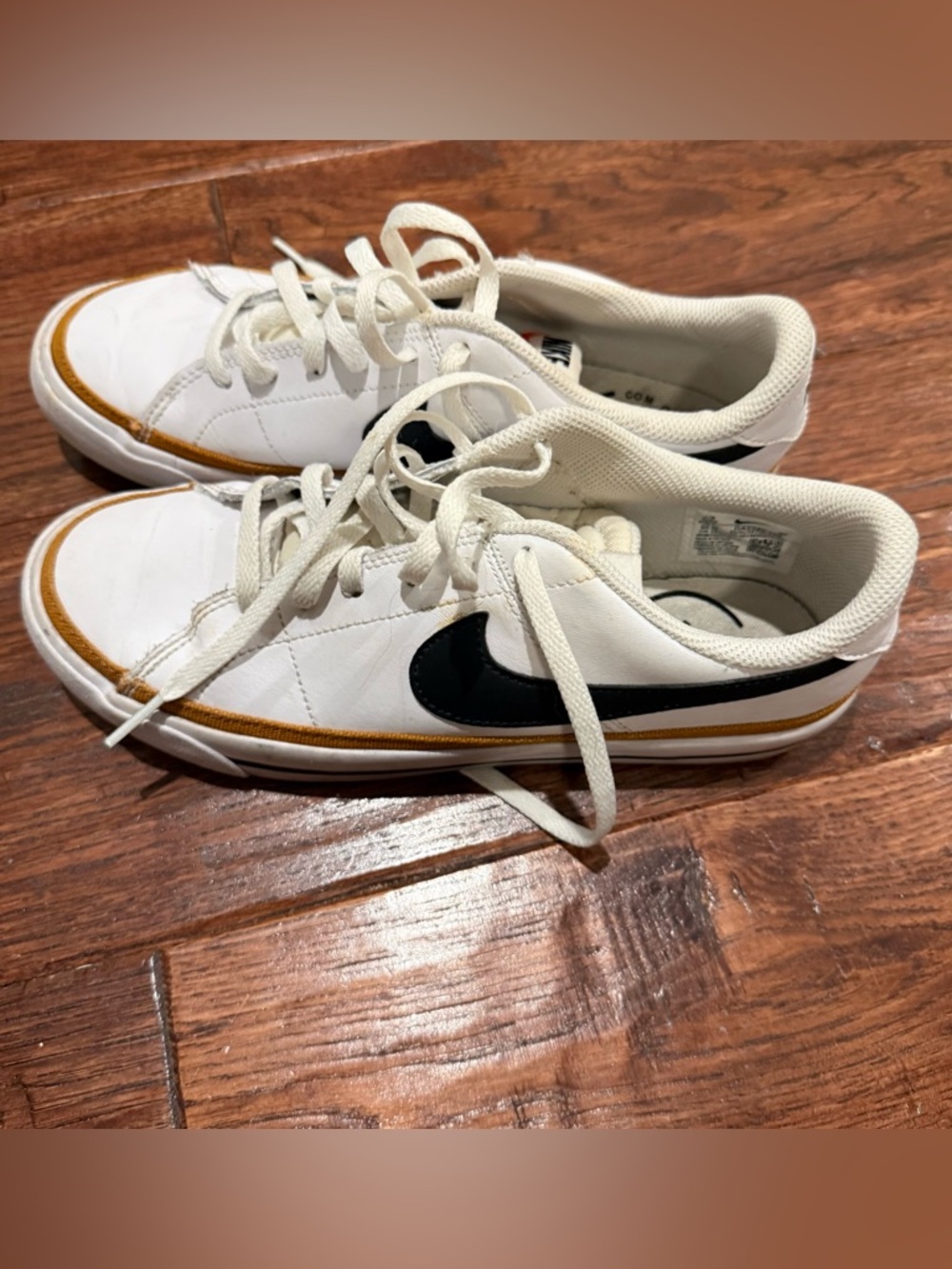 Nike White Low-Top Sneakers with Black Swoosh and Gold Accent